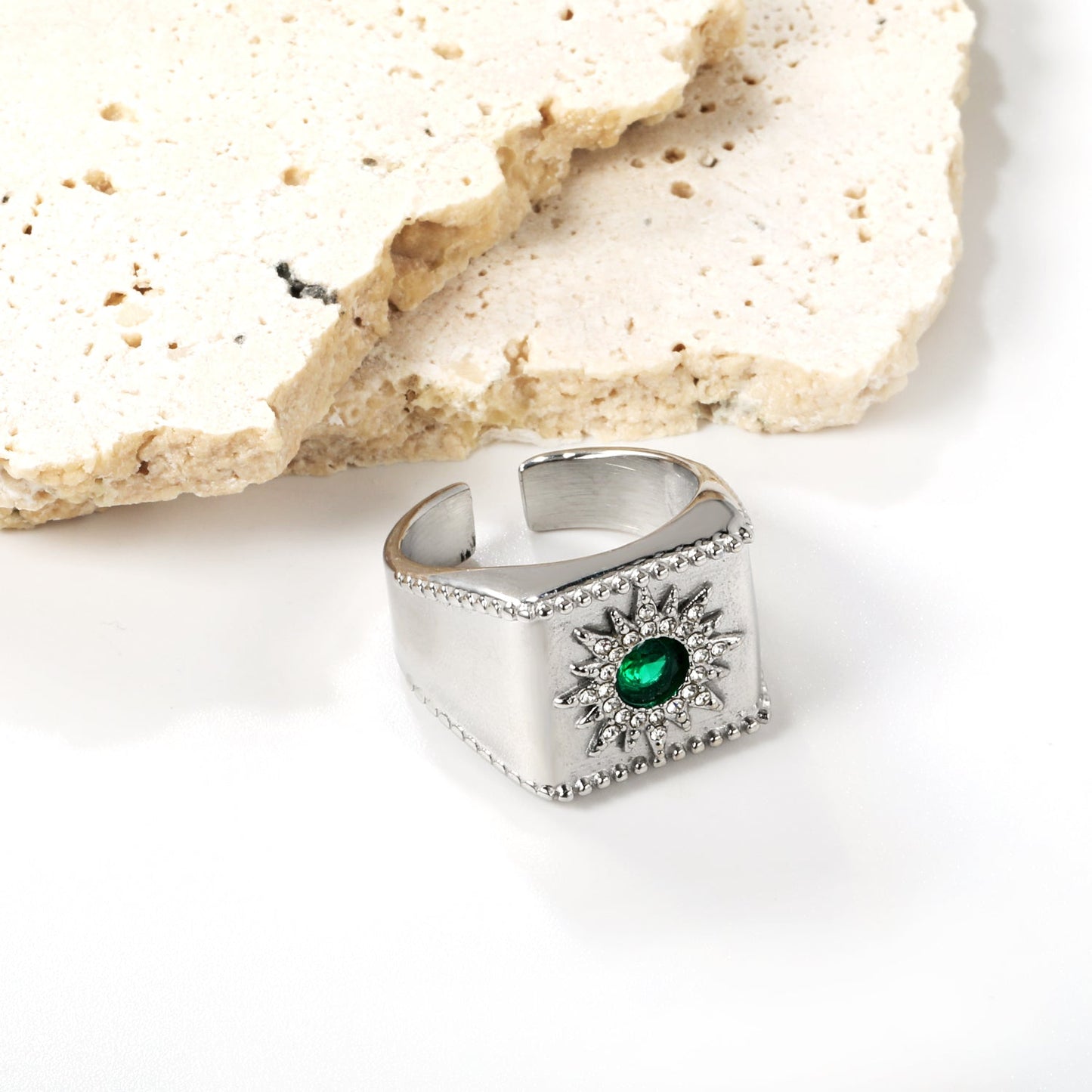 Exaggerated ring with green diamonds and engraved stamens.