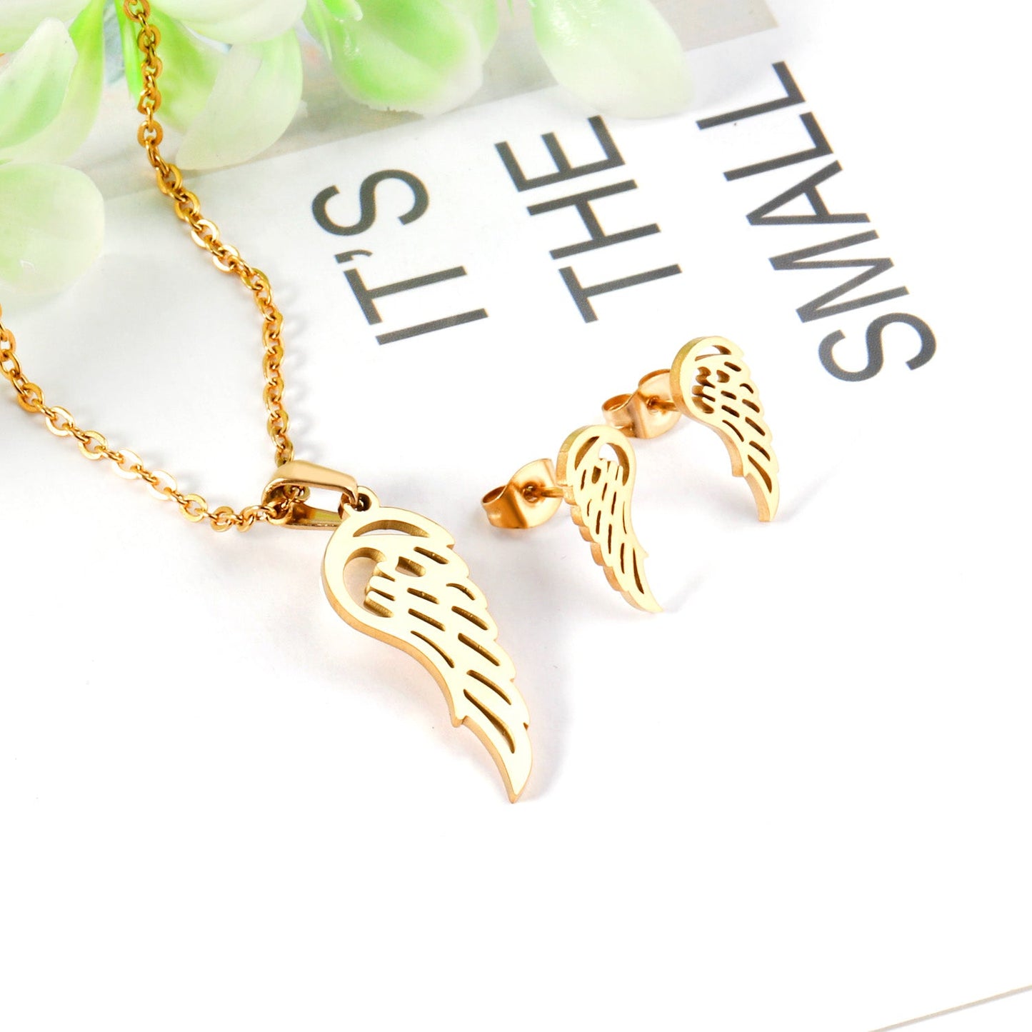 Steel/golden half of a wing shape faceted cut jewelry set without diamonds