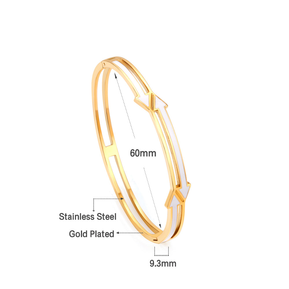 Gold colored hard bracelet with directional arrows with oil dripping in the center white color