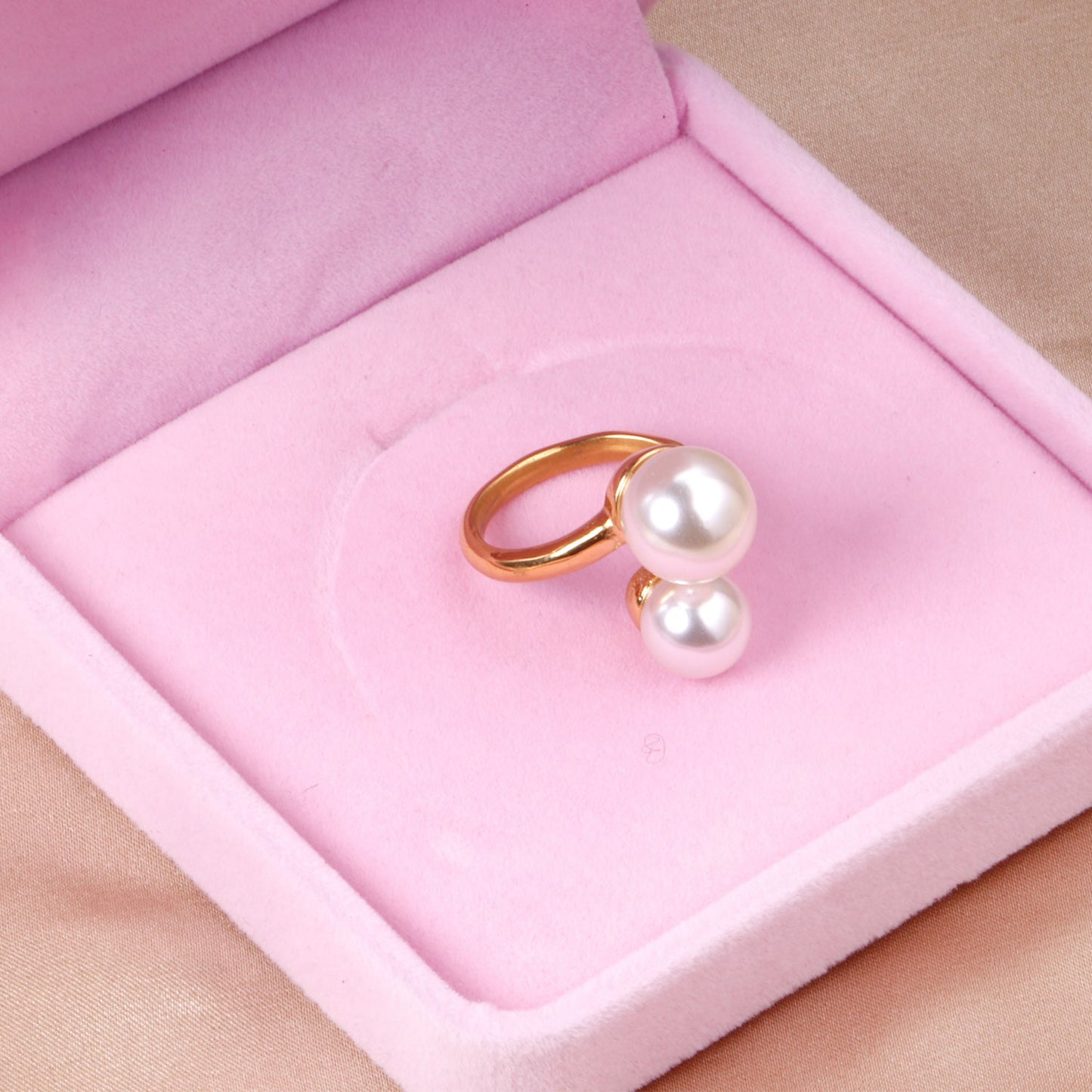 Two large and two small pearls in open pearl setting ring