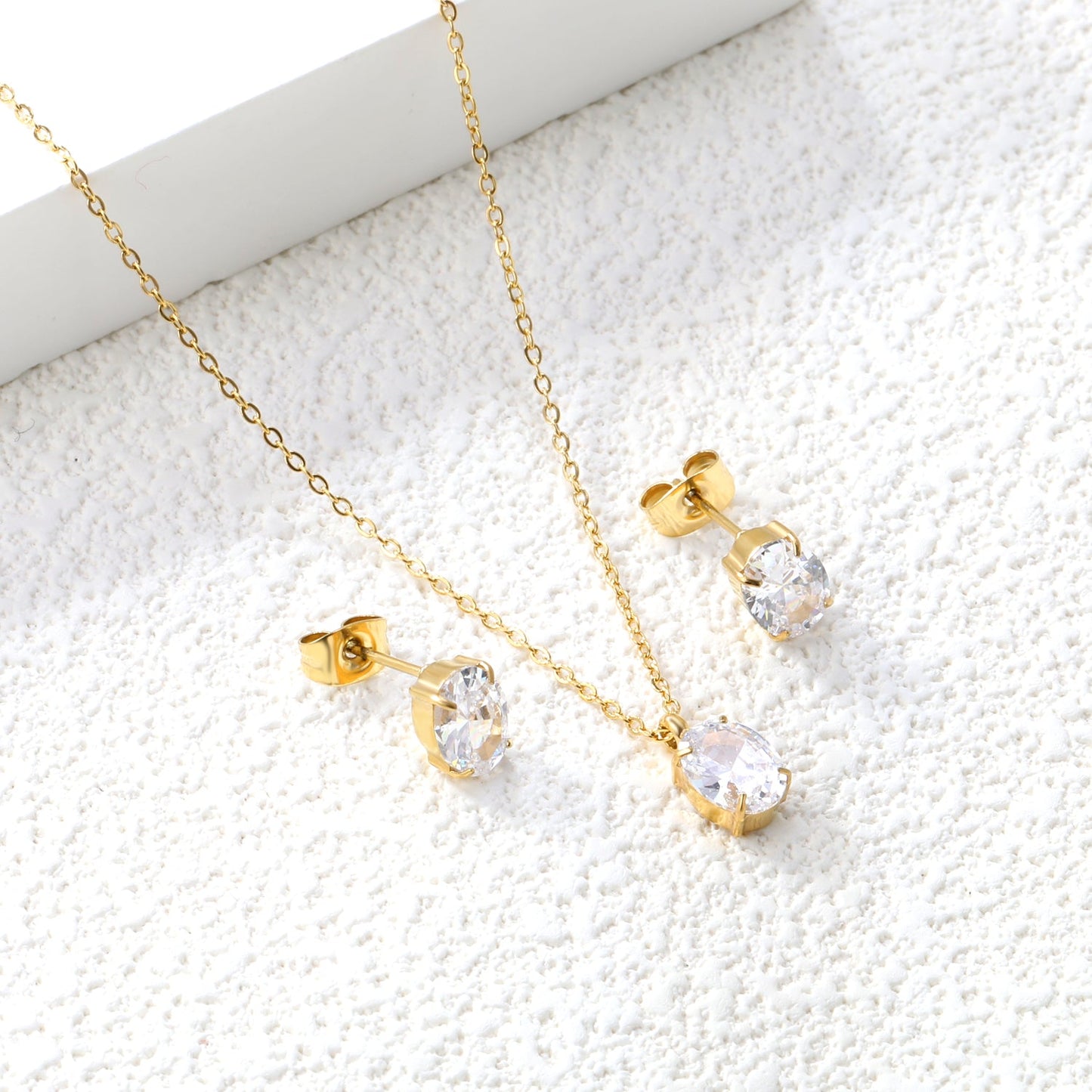 Oval white zirconium set Gold-colored earrings: 6*8mm Pendant: 6*8mm 0.3 cross chain *40+5cm+6mm round plate