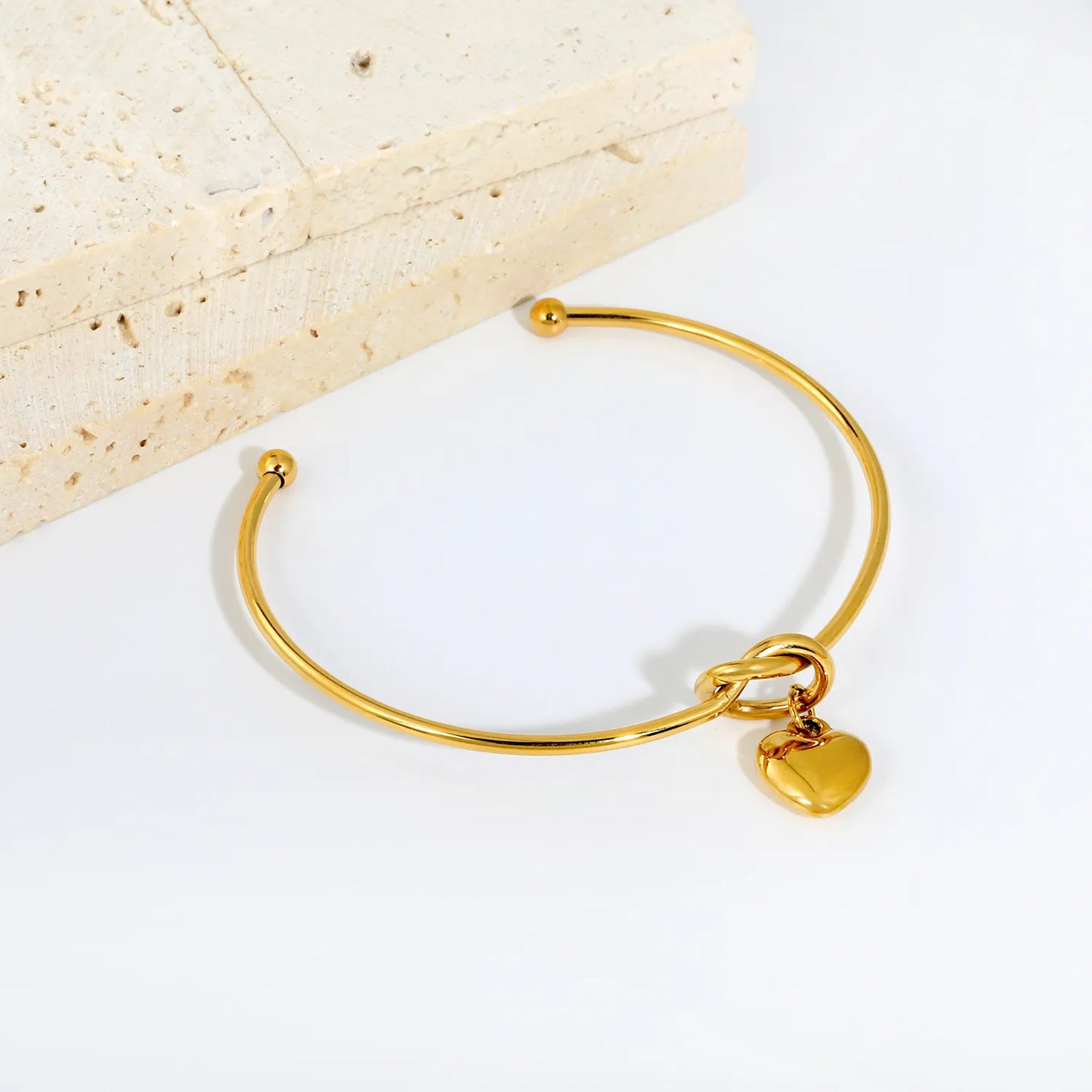 Knot Heart Charm Open Cuff Bangle | 63mm Overall Length | 13.5×11.5mm Knot Detail | 11×12mm Solid Heart Pendant | 18K Gold Plated Stainless Steel Bracelet for Wholesale Supply