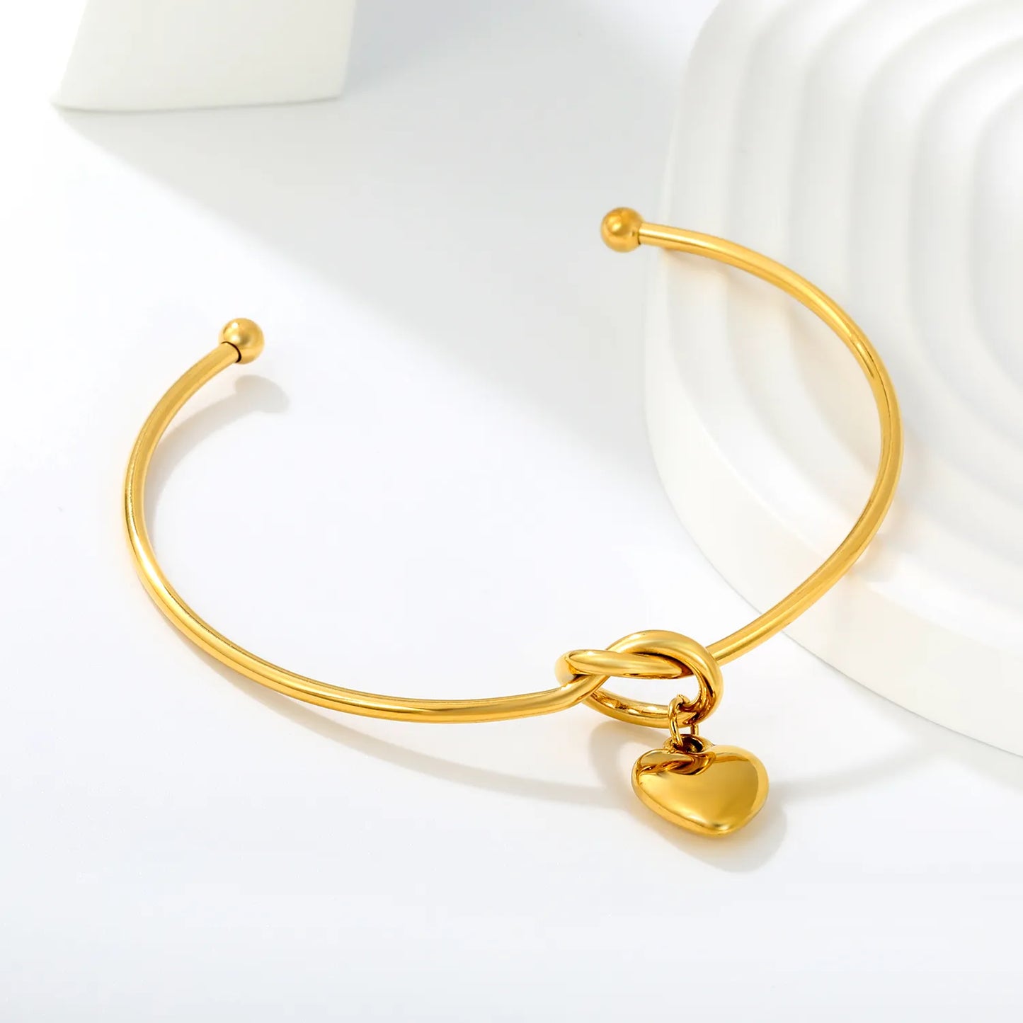 Knot Heart Charm Open Cuff Bangle | 63mm Overall Length | 13.5×11.5mm Knot Detail | 11×12mm Solid Heart Pendant | 18K Gold Plated Stainless Steel Bracelet for Wholesale Supply