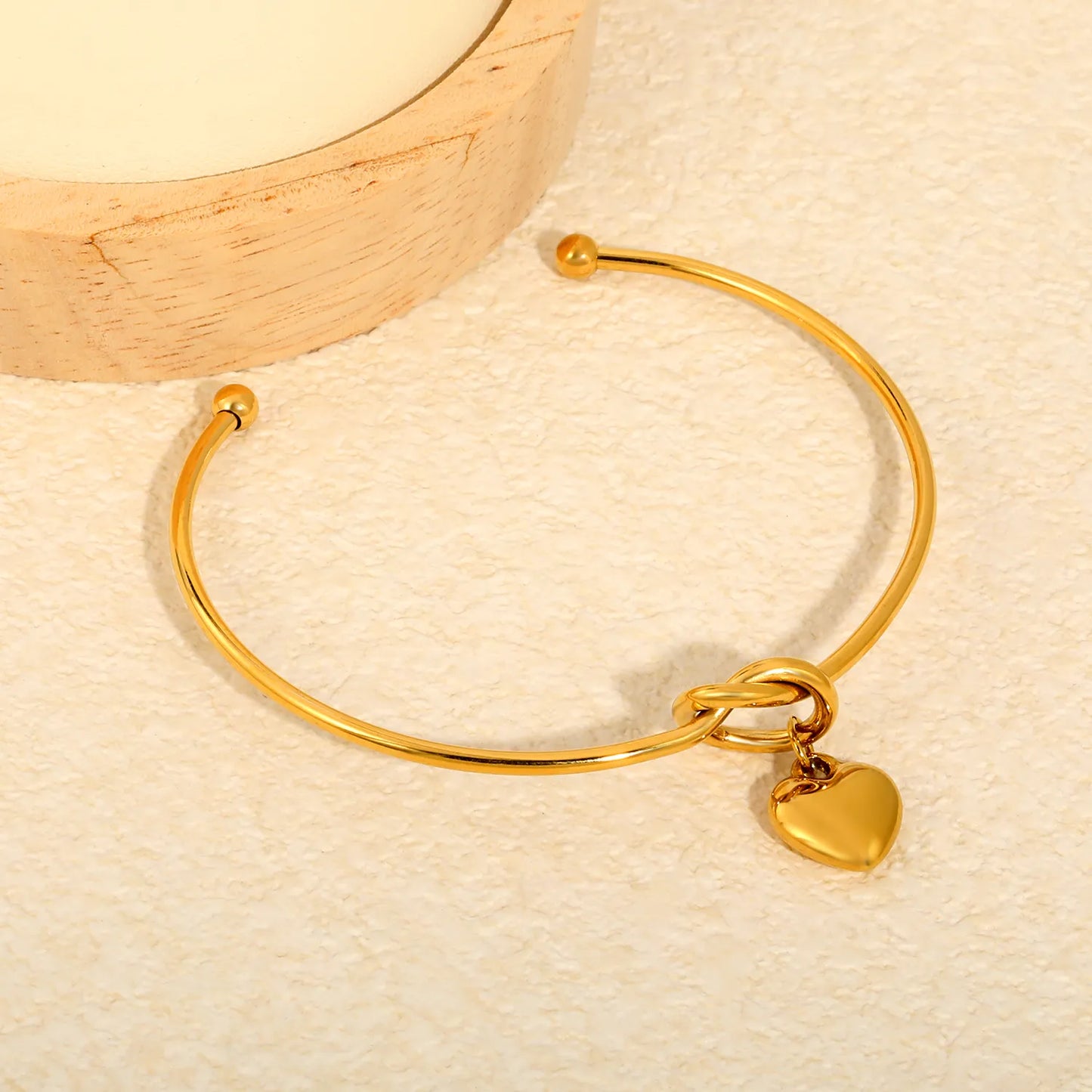 Knot Heart Charm Open Cuff Bangle | 63mm Overall Length | 13.5×11.5mm Knot Detail | 11×12mm Solid Heart Pendant | 18K Gold Plated Stainless Steel Bracelet for Wholesale Supply