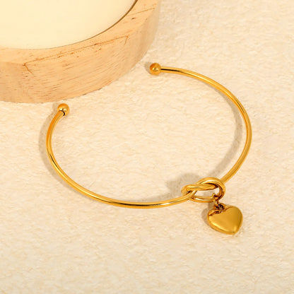 Knot Heart Charm Open Cuff Bangle | 63mm Overall Length | 13.5×11.5mm Knot Detail | 11×12mm Solid Heart Pendant | 18K Gold Plated Stainless Steel Bracelet for Wholesale Supply